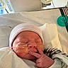 Alaysia is registered to the contest to win money with this photo: newborn, baby, hospital, blanket, hat, face, infant, pacifier, medical_tape, close_up, sleeping, person, hand, skin, bed, healthcare, cute, peace_sign, resting, wrapped