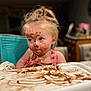 child, toddler, face_paint, chocolate, messy, highchair, blue_eyes, blonde_hair, indoor, curious, pink_clothing, dining, food, tray, smudged, portrait, cute, baby, eating, fun