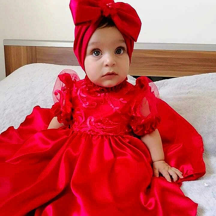 Elisa a rejoint le concours — aidez-le/la à gagner de superbes lots ! baby, bed, bow, child, clothing, curious, cute, dress, eyes, fabric, face, fancy, hands, headband, indoors, infant, portrait, red_dress, sitting, young_child