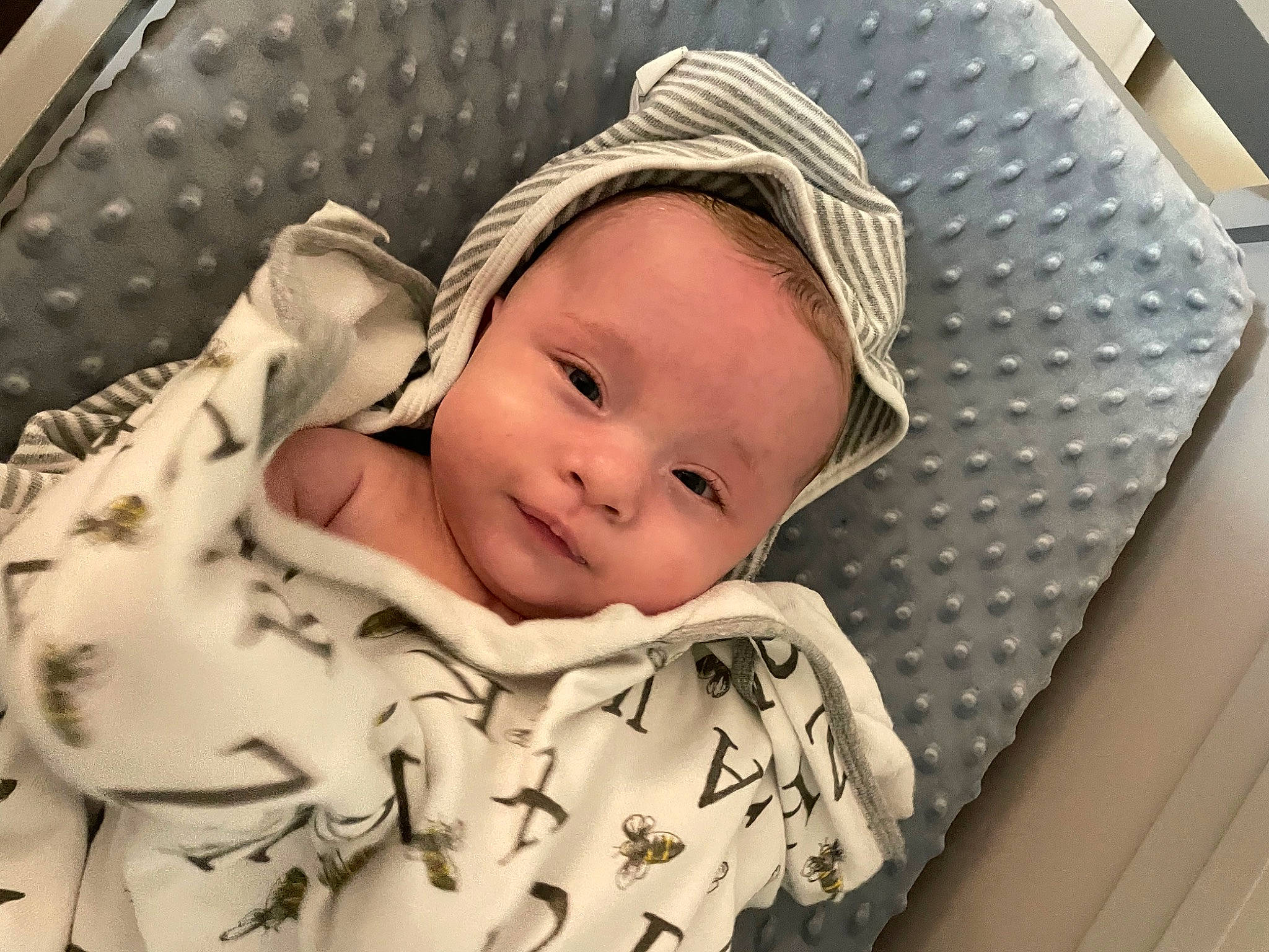 Daniel is registered to the contest to win money with this photo: baby, baby_toddler_clothing, cap, cheek, child, chin, comfort, eye, face, fashion_accessory, happy, hat, linens, pattern, person, product, skin, sleeve, sun_hat, textile