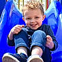 David Leland is registered to the contest to win money with this photo: child, toddler, smiling, curly_hair, blue_slide, playground, outdoor, happy, casual_clothing, shoes, fun, joy, play, recreation, daylight, park, young_child, active, leisure, cute