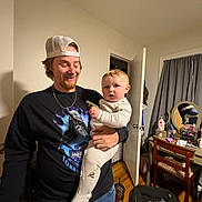 Oaklen joined the competition — help win amazing prizes! baby, man, child, indoor, person, clothing, cap, pajamas, furniture, vanity, mirror, dog, floor, door, curtains, room, smile, holding, happy, jewelry