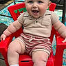 Oaklen is registered to the contest to win money with this photo: baby, child, smiling, red_chair, socks, striped_shorts, beige_shirt, outdoor, deck, wood_floor, happy, blue_eyes, short_hair, cute, infant, person, seated, summer_clothing, joyful, playful