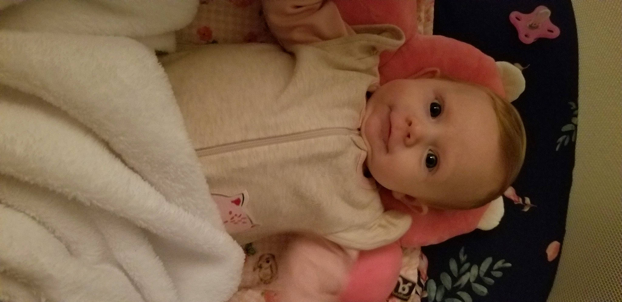 Rosalee is registered to the contest to win money with this photo: baby, bedtime, cheek, child, eye, face, facial_expression, finger, hand, head, infant_bed, iris, lip, mouth, nose, person, pink, skin, smile, textile