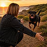 Ohana a rejoint le concours — aidez-le/la à gagner de superbes lots ! dog, person, sunset, coast, path, outdoor, nature, happy, running, smiling, black_jacket, casual_shoes, greenery, hills, ocean, sky, clouds, reunion, pet, landscape