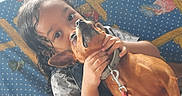 Ti Belle participe au concours pour gagner de l'argent avec cette photo : affection, brown_dog, child, closeup, collar, cuddle, curly_hair, cute, dog, expression, fabric, holding, indoor, leash, pattern, pet, playful, polka_dot, together, young