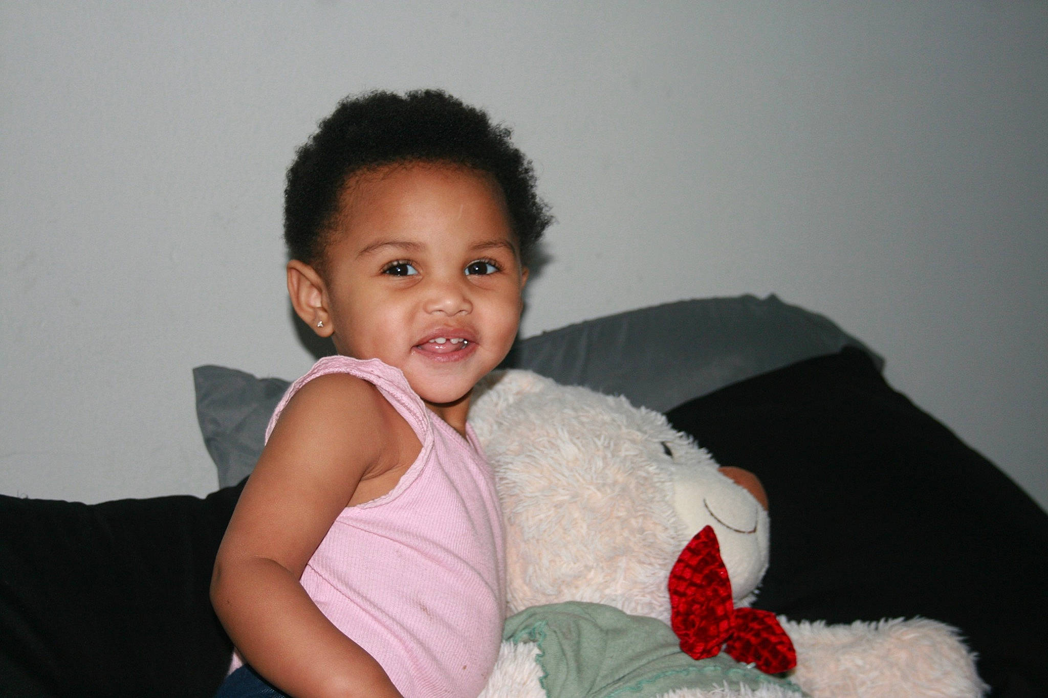 Kimani is registered to the contest to win money with this photo: abdomen, arm, baby_toddler_clothing, cheek, comfort, couch, event, eye, flash_photography, happy, head, iris, person, room, shoulder, sitting, skin, smile, textile, toddler