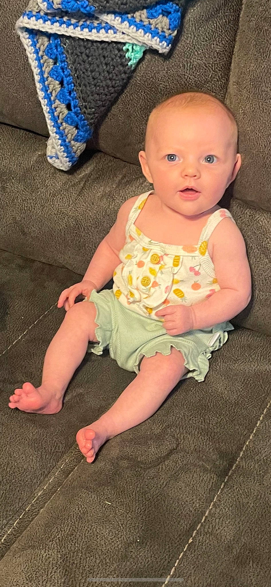 Araya is registered to the contest to win money with this photo: baby, baby_toddler_clothing, cheek, child, comfort, couch, eye, foot, grass, head, human_leg, iris, lap, pattern, person, pink, sitting, skin, sleeve, sock