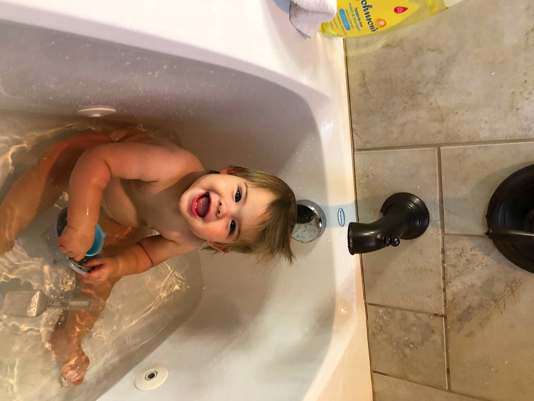 Leighton is registered to the contest to win money with this photo: bathing, bathroom, bathtub, beauty, child, composite_material, flesh, fluid, fun, happy, leisure, person, personal_care, plumbing, plumbing_fixture, room, smile, tap, water