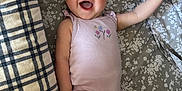 Ella joined the competition — help win amazing prizes! baby, infant, smiling, happy, onesie, blanket, patterned_blanket, lying_down, arm_up, barefoot, portrait, cute, child, young_child, indoor, fabric, plaid_blanket, floral_pattern, skin, person