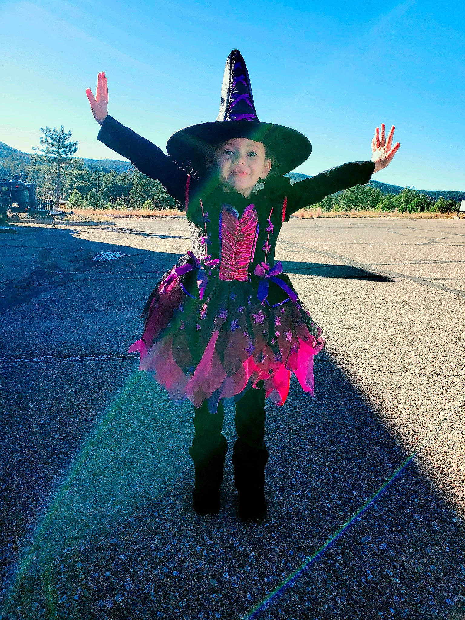 Kiara is registered to the contest to win money with this photo: costume_hat, dress, electric_blue, event, fun, grass, happy, hat, headgear, headwear, landscape, magenta, pattern, people_in_nature, person, pink, purple, sky, sun_hat, travel