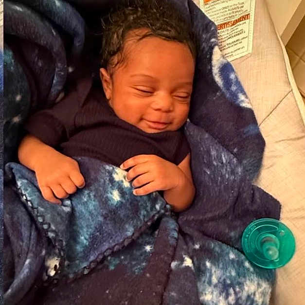 Ashai is registered to the contest to win money with this photo: baby, infant, blanket, blue_blanket, pacifier, sleeping, smiling, cozy, cushion, seat, cute, newborn, child, indoors, comfort, peaceful, resting, clothing, human, portrait