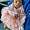 Ashai is registered to the contest to win money with this photo: baby, infant, sleeping, pink_dress, ruffles, cartoon_print, hands, socks, person, car_interior, seat, blue_clothing, cute, peaceful, newborn, child, closeup, portrait, resting, soft_fabric