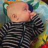 Theodore is registered to the contest to win money with this photo: baby, infant, child, striped_clothing, thumb_sucking, play_mat, aquatic_theme, colorful, fish, indoor, cute, portrait, side_view, young_child, soft_lighting, casual, relaxed, human, one_person, baby_garments