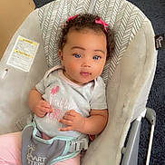Jenesis is registered to the contest to win money with this photo: baby, child, baby_rocker, curly_hair, pink_bows, grey_shirt, pink_pants, carpet, indoor, infant, seated, cute, looking_at_camera, soft_toys, comfortable, childcare, baby_gear, face, person, young_child