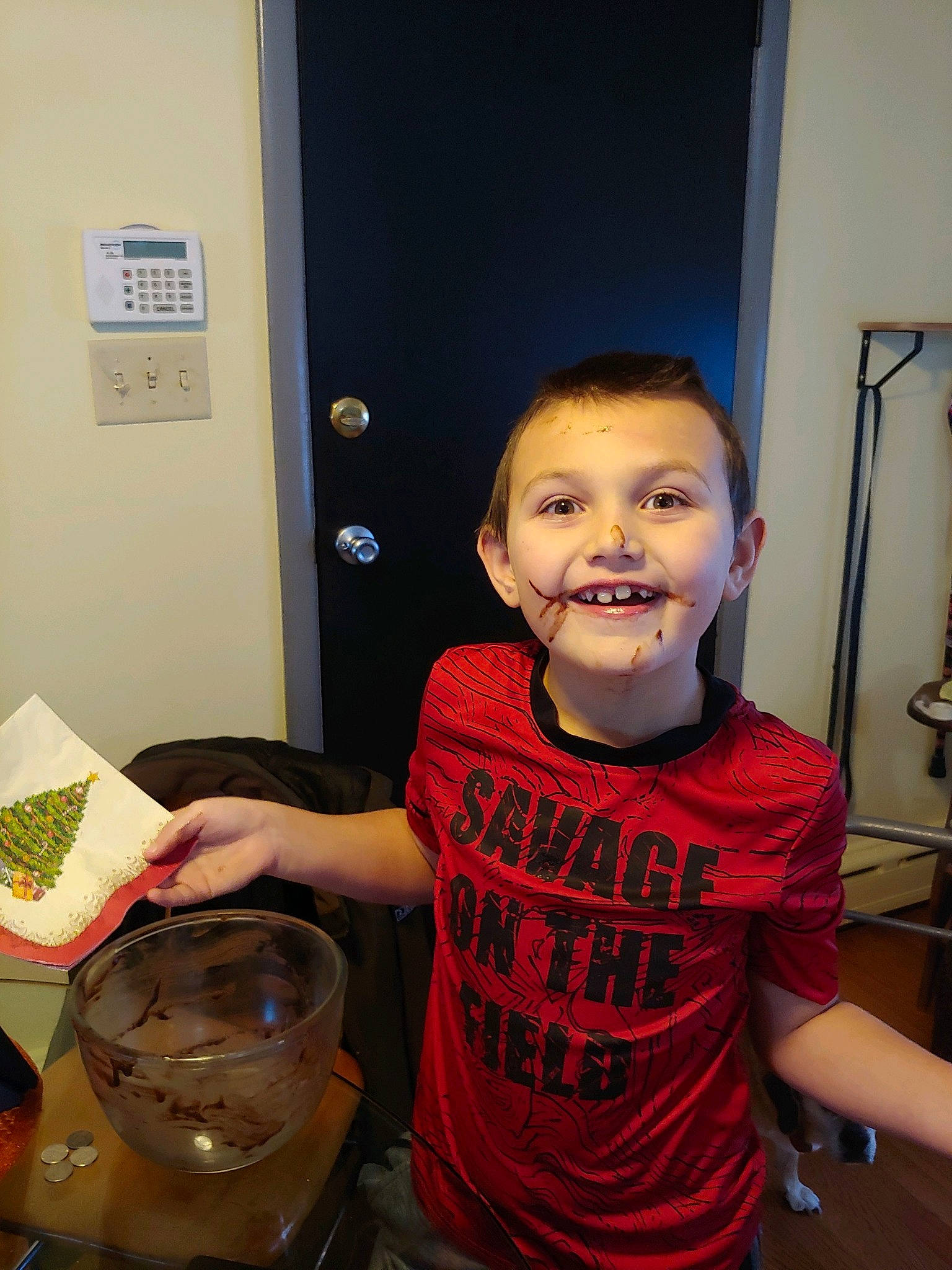 Abel is registered to the contest to win money with this photo: bowl, chair, child, cooking, door, drink, drinkware, flooring, fun, happy, joy, person, plate, refrigerator, room, sitting, smile, t_shirt, table, tableware