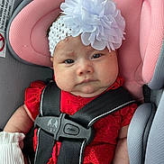 Madison joined the competition — help win amazing prizes! baby, car_seat, headband, flower, red_clothing, white_mittens, infant, child, seatbelt, safety_harness, pink_cushion, gray_fabric, cute, portrait, indoors, closeup, face, expression, child_safety, newborn