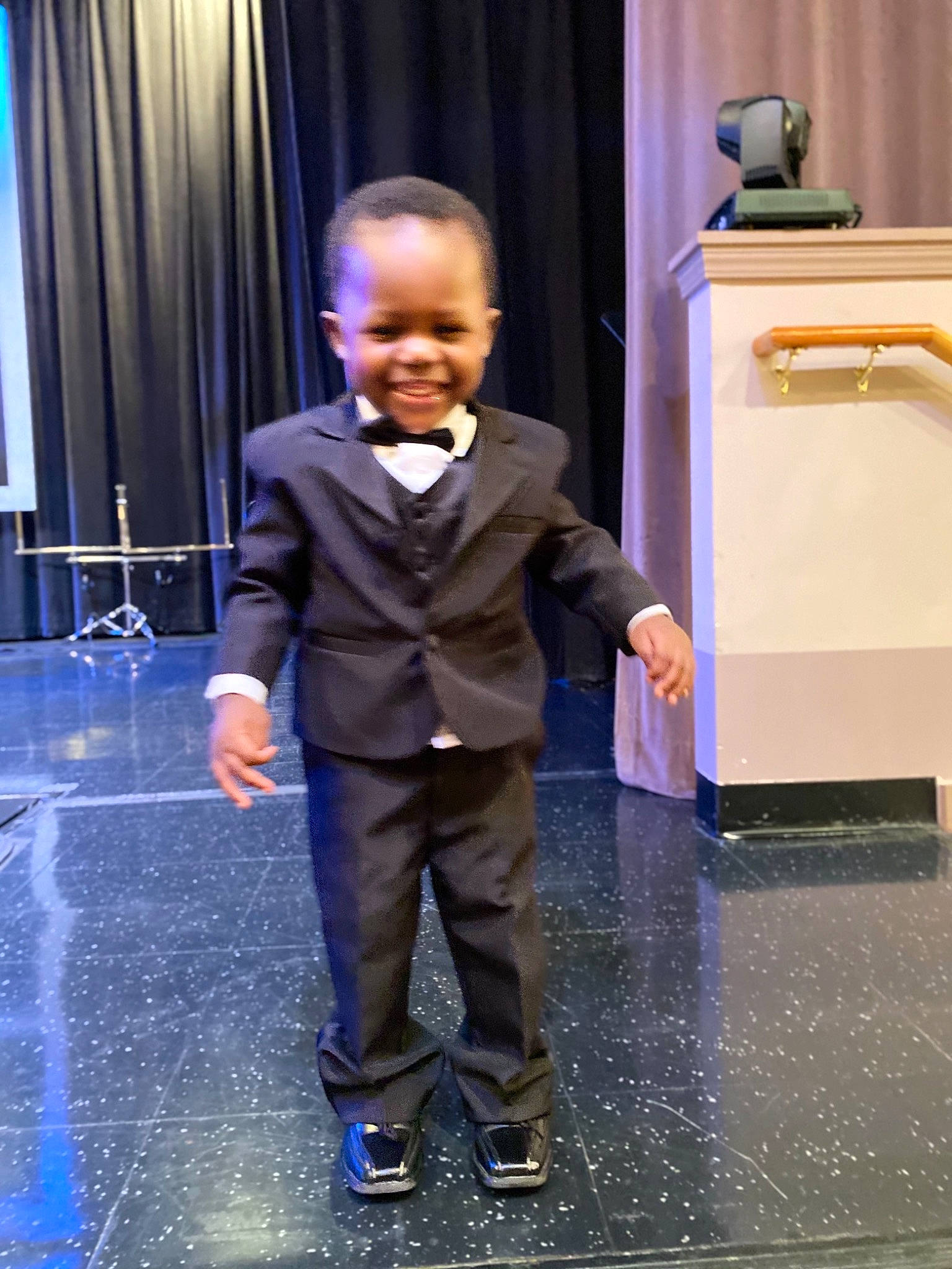 Micheal joined the competition — help win amazing prizes! chair, child, curtain, electric_blue, entertainment, event, fashion_design, floor, flooring, formal_wear, fun, happy, joy, leisure, performing_arts, person, purple, shoulder, smile, standing