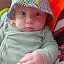 Logan participe au concours pour gagner de l'argent avec cette photo : baby, bucket_hat, child, close_up, clothing, cute, eyes, face, green_onesie, hand, hat, indoor, infant, octopus_toy, patterned_background, person, serious_expression, striped, teething_toy, yellow_ducks