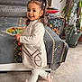bicycle_pattern, boots, carpet, child, couch, cozy, floor, furniture, happy, home, indoor, person, pigtails, plant, portrait, smiling, sweater_dress, toddler, toy, white_tights