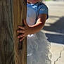 child, girl, smiling, barefoot, tutu, blue_shirt, wooden_post, outdoor, sunlight, concrete, crack, playful, happy, portrait, young_child, daylight, grass, shadow, cute, standing