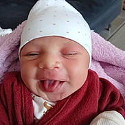 Rosa-Lyia Bouhi participe au concours pour gagner de l'argent avec cette photo : baby, infant, face, tongue_out, hat, polka_dot, red_sweater, blanket, pink_blanket, couch, cushion, indoor, cute, playful, child, smiling, person, portrait, newborn, cozy