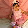 baby, girl, pink_dress, headband, smiling, sitting, pink_background, shoes, sock, cute, child, infant, happy, portrait, indoors, soft_surface, colorful_shoes, fabric, apparel, person