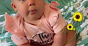 Charlotte is registered to the contest to win money with this photo: baby, infant, pink_bow, pink_clothing, sunflowers, floral_blanket, curtains, indoors, child, cute, portrait, sitting, headband, hands, feet, expression, decorative_flowers, green_background, soft_lighting, young_child