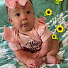 baby, infant, pink_bow, pink_clothing, sunflowers, floral_blanket, curtains, indoors, child, cute, portrait, sitting, headband, hands, feet, expression, decorative_flowers, green_background, soft_lighting, young_child