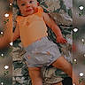 baby, infant, bow, orange_clothing, shorts, floral_blanket, smiling, lying_down, cute, child, portrait, indoors, patterned_fabric, happy, person, headband, small_child, skin, baby_girl, background_blur