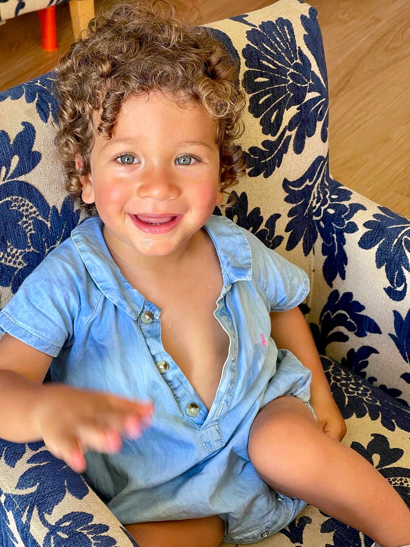 Leon participe au concours pour gagner de l'argent avec cette photo : child, toddler, curly_hair, blue_eyes, smiling, armchair, blue_shirt, happy, indoor, cute, portrait, person, furniture, hand, skin, buttoned_shirt, seat, playful, baby, young_child