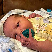 Jaxson is registered to the contest to win money with this photo: baby, infant, pacifier, blanket, yellow_clothing, giraffe_print, hand, face, couch, newborn, skin, cute, resting, soft, indoor, portrait, closeup, child, young, comfort
