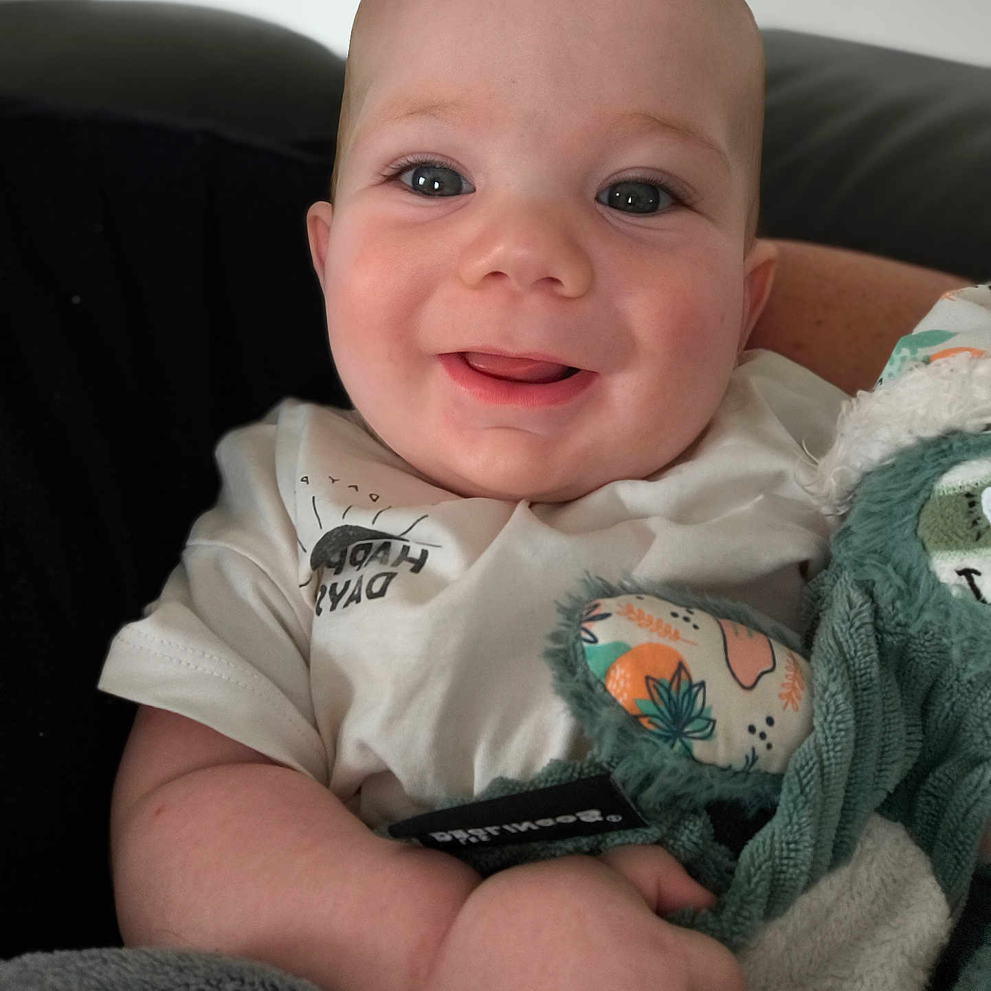 Eliott participe au concours pour gagner de l'argent avec cette photo : baby, blanket, child, closeup, clothing, cute, eyes, face, hand, happy, head, indoor, infant, person, plush_toy, portrait, sitting, skin, smiling, soft_toy