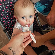 Amara joined the competition — help win amazing prizes! baby, child, feeding, fork, stroller, hand, indoor, blue_eyes, curious, polka_dot, clothing, person, footwear, tattoo, floor, seat, adult, skin, toy, expression
