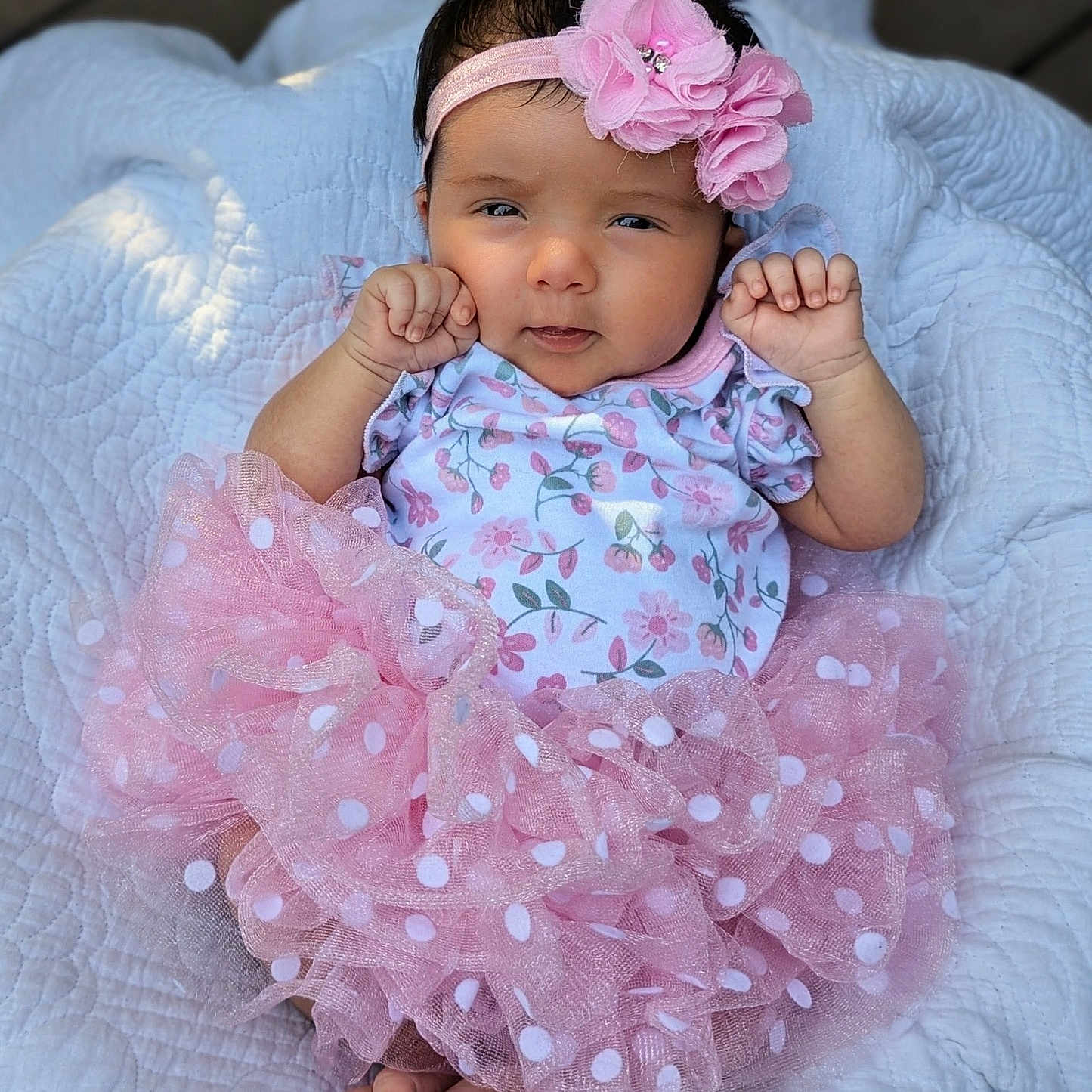 Annabel is registered to the contest to win money with this photo: baby, blanket, child, clothing, cute, face, feet, flower, hands, headband, infant, newborn, onesie, outdoor, pink, polka_dot, portrait, quilt, smile, tutu