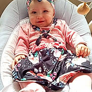 Kessy Chapoulaud a rejoint le concours — aidez-le/la à gagner de superbes lots ! baby, child, smiling, headband, pink_clothing, floral_skirt, baby_chair, cushion, indoor, happy, cute, portrait, infant, person, soft_lighting, fashion, seated, adorable, baby_toys, comfort