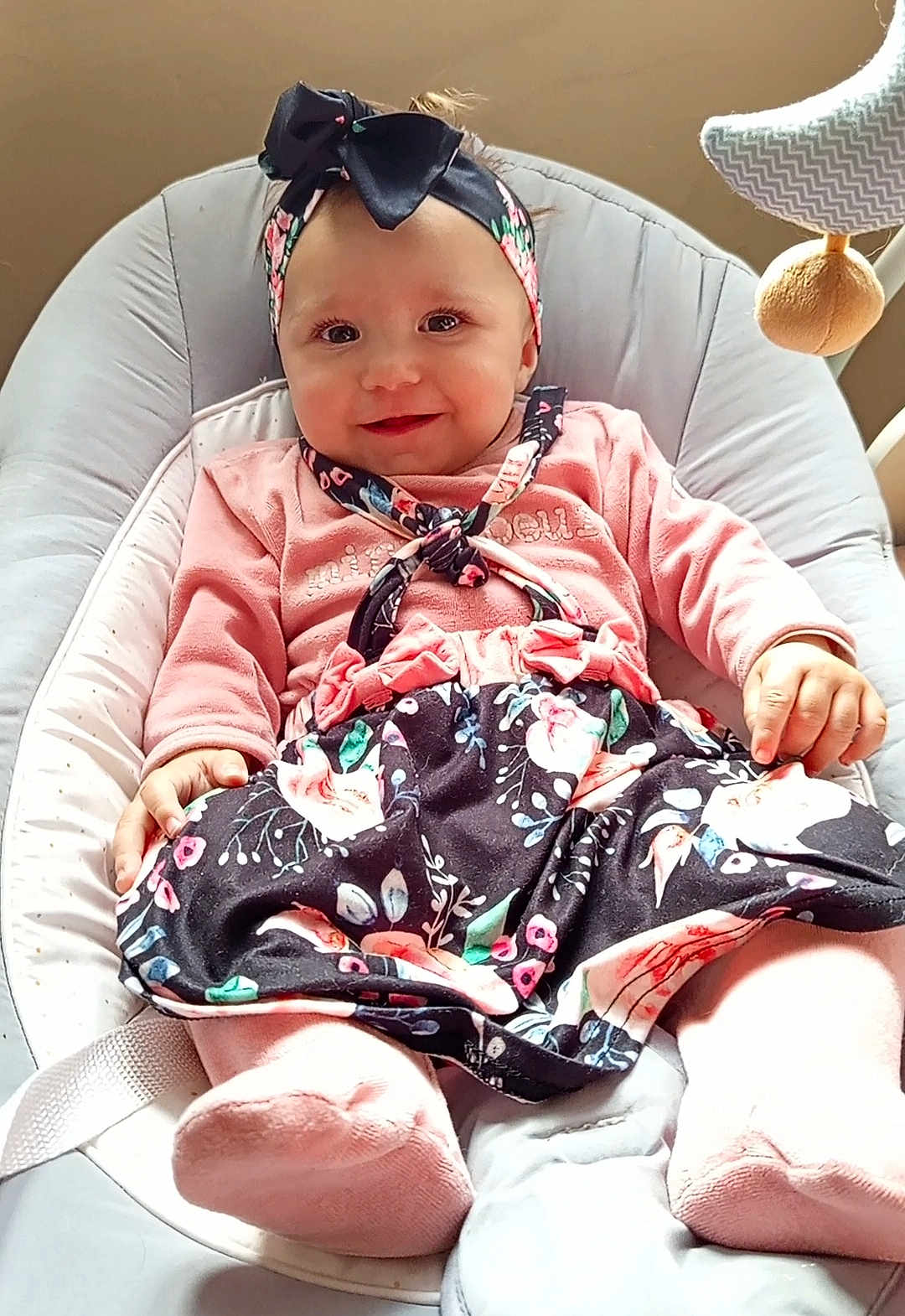 Kessy Chapoulaud a rejoint le concours — aidez-le/la à gagner de superbes lots ! baby, child, smiling, headband, pink_clothing, floral_skirt, baby_chair, cushion, indoor, happy, cute, portrait, infant, person, soft_lighting, fashion, seated, adorable, baby_toys, comfort