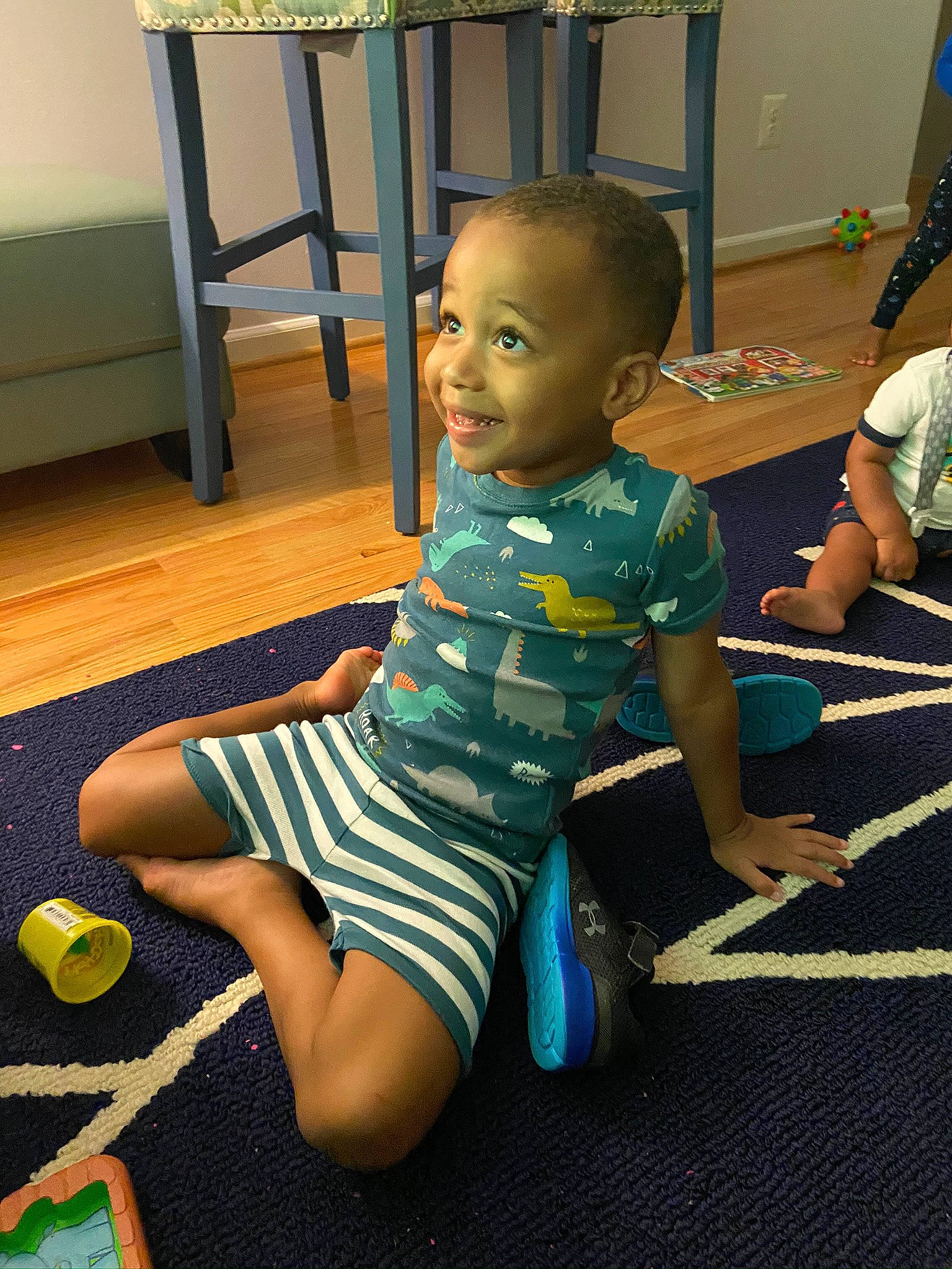 Noah is registered to the contest to win money with this photo: arm, child, human_leg, joint, knee, leg, leisure, person, play, room, sitting, toddler, trunk