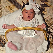 Magnolia joined the competition — help win amazing prizes! baby, infant, girl, tutu, headband, bow, basket, blanket, white_clothing, pink_tutu, carpet, soft_texture, lying_down, cute, curious, expression, indoors, child, small_hands, small_feet