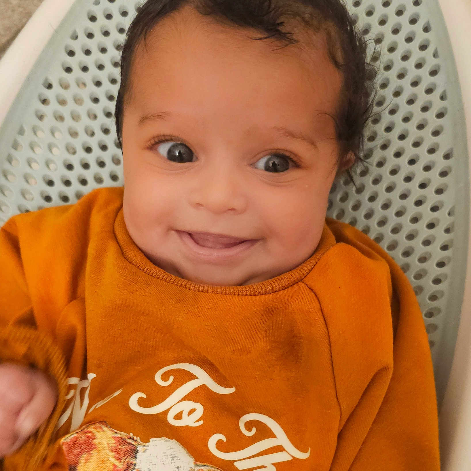 Magnolia is registered to the contest to win money with this photo: baby, smiling, orange_sweater, cow_print, face, portrait, child, infant, happy, clothing, cute, young, lying_down, basket, white, indoors, close_up, skin, head, eyes