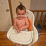 toddler, child, high_chair, mohawk, smile, shirtless, food_crumbs, indoor, wooden_floor, door, door_knob, baby, plastic_chair, orange_seat, happy, person, face, hands, hair, water_jug