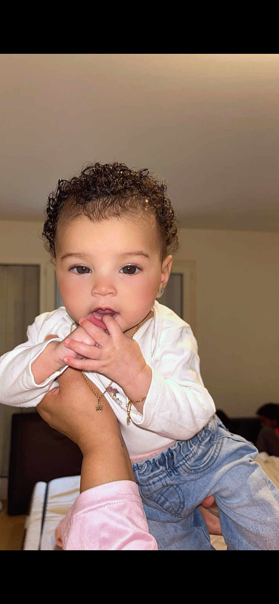 Alanny Kathleya participe au concours pour gagner de l'argent avec cette photo : toddler, child, curly_hair, indoor, person, baby, hand, white_shirt, denim_pants, jewelry, earrings, portrait, cute, holding, skin, face, eyes, fingers, expression, home