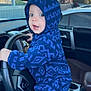 baby, blue_onesie, car_interior, car_seat, child, cute, dashboard, hand_on_wheel, hoodie, indoor, infant, mirror, person, seat, seatbelt, steering_wheel, surprised_expression, vehicle, window, young_child