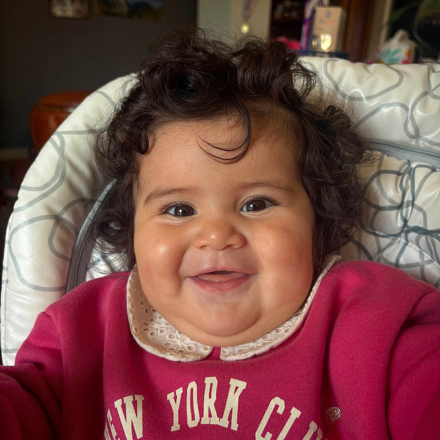 Blanca Lucia a rejoint le concours — aidez-le/la à gagner de superbes lots ! baby, child, closeup, clothing, cozy, curly_hair, cute, expression, face, happy, high_chair, home, indoor, infant, person, portrait, red_sweatshirt, sitting, smiling, young_child
