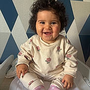 Blanca Lucia participe au concours pour gagner de l'argent avec cette photo : baby, blanket, child, clothing, cream_color, curly_hair, cute, face, geometric_pattern, happy, indoor, infant, patterned_clothes, person, pink, portrait, sitting, smiling, socks, wallpaper