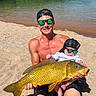 beach, lake, man, baby, fish, sunglasses, hat, sand, water, nature, outdoor, sunlight, reflection, summer, casual, fishing, child, adult, recreation, vacation