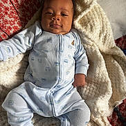 Xonyx is registered to the contest to win money with this photo: baby, infant, pajamas, blanket, bed, pillow, floral_pattern, face, sleepwear, person, cozy, indoors, child, cute, soft_texture, lying_down, comfort, relaxing, home, blanket_texture