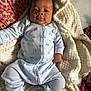 baby, infant, pajamas, blanket, bed, pillow, floral_pattern, face, sleepwear, person, cozy, indoors, child, cute, soft_texture, lying_down, comfort, relaxing, home, blanket_texture