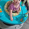 baby, child, walker, purple_shirt, toy, floor, indoor, play, infant, cute, childhood, furniture, expression, tongue_out, colorful, seat, person, young, happy, looking_up
