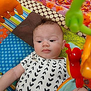 Dante joined the competition — help win amazing prizes! baby, baby_clothes, bright_colors, butterfly_toy, child, closeup, colorful, curious, cute, face, happy, indoor, infant, lying_down, patterned_clothing, play_mat, playtime, soft_lighting, toy, young_child